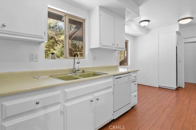 kitchen featuring white cabinets, white dishwasher, a sink, light countertops, and wood finished floors