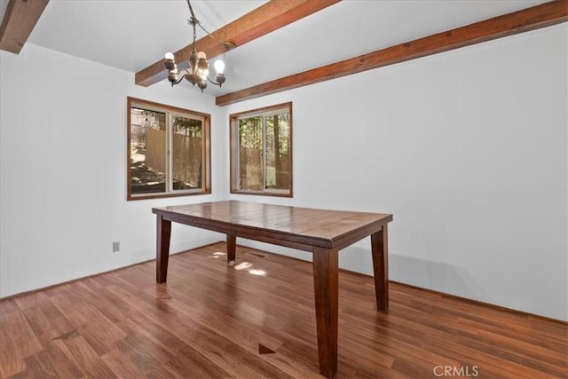 unfurnished dining area with beamed ceiling, an inviting chandelier, and wood finished floors