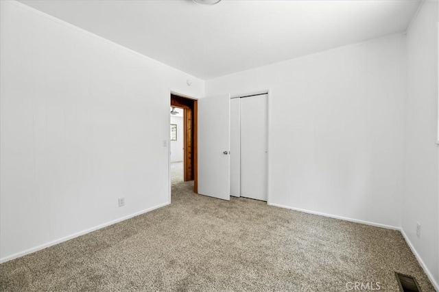 carpeted spare room with baseboards and visible vents