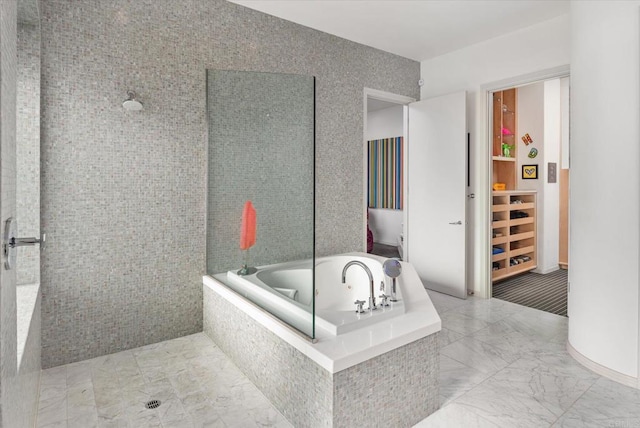 bathroom featuring a whirlpool tub and marble finish floor