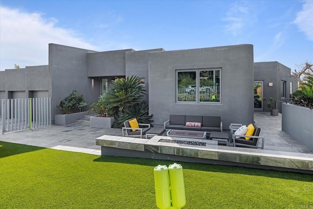 back of property featuring an outdoor living space with a fire pit, fence, stucco siding, a patio area, and a yard