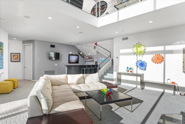 carpeted living area featuring stairs, recessed lighting, and visible vents
