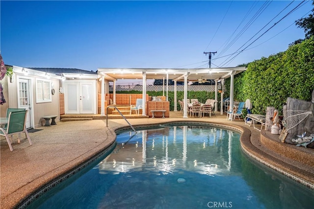 view of swimming pool with fence, a fenced in pool, french doors, and a patio area
