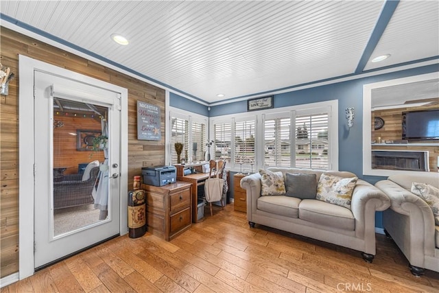living room with recessed lighting, ornamental molding, wood walls, and hardwood / wood-style floors