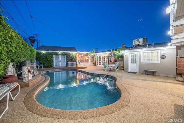 view of swimming pool featuring central AC, fence, a patio, french doors, and a fenced in pool