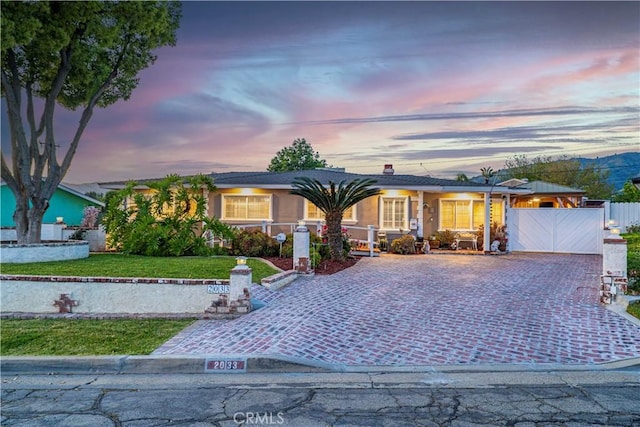 ranch-style house with fence, driveway, and a front yard