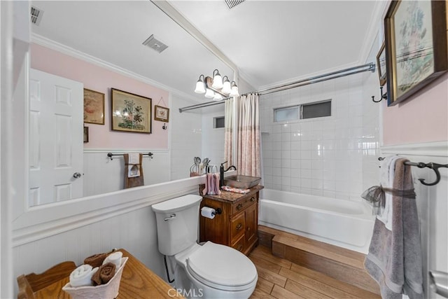 bathroom with crown molding, shower / bath combination with curtain, wood finished floors, and visible vents