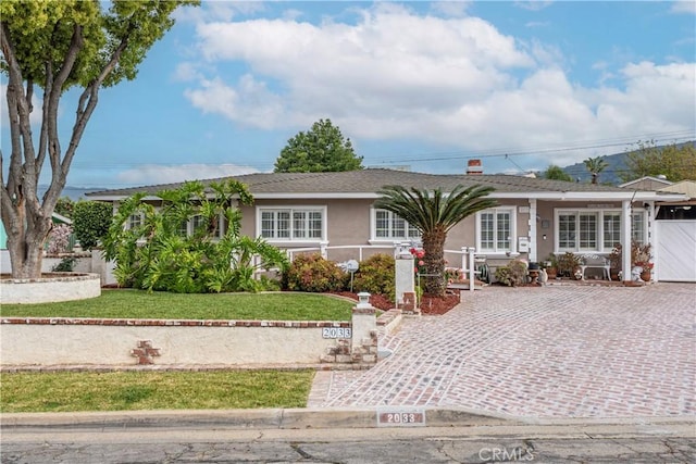 ranch-style house with a front yard and stucco siding