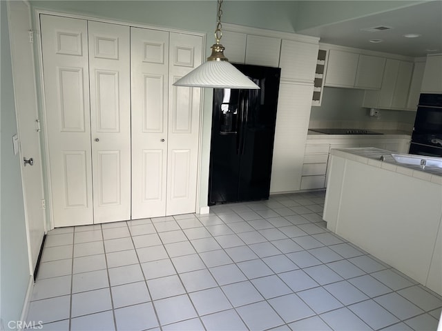 17 Marseille, Laguna Niguel, CA 92677 - kitchen with visible vents, hanging light fixtures, light tile patterned floors, black appliances, and white cabinetry