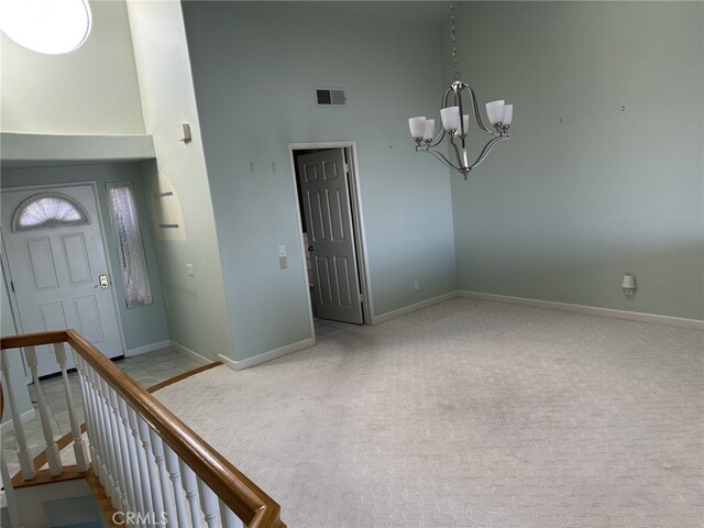 17 Marseille, Laguna Niguel, CA 92677 - carpeted foyer entrance with visible vents, baseboards, a towering ceiling, and a notable chandelier