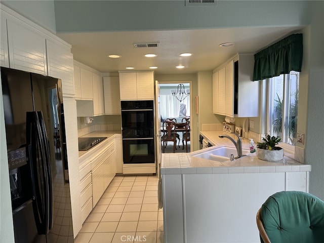 17 Marseille, Laguna Niguel, CA 92677 - kitchen featuring tile countertops, a sink, light tile patterned floors, black appliances, and a peninsula