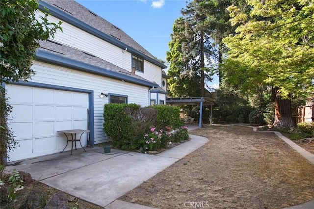 3716 Viader Dr, Modesto, CA 95356 - view of side of property with a pergola, a patio, and a shingled roof