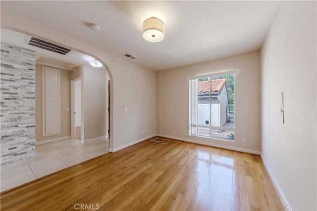 11449 Tampa Ave Unit 139, Porter Ranch, CA 91326 - spare room featuring visible vents, arched walkways, light wood-style flooring, and baseboards