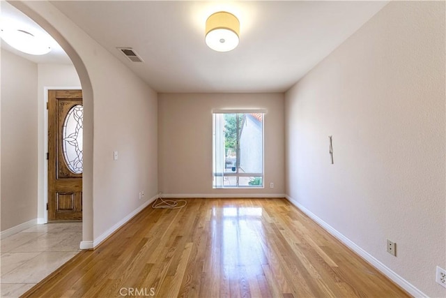 11449 Tampa Ave Unit 139, Porter Ranch, CA 91326 - entrance foyer with visible vents, arched walkways, light wood finished floors, and baseboards