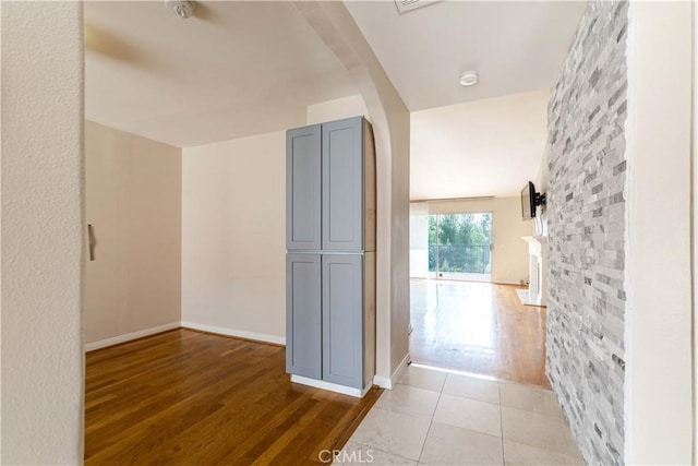 11449 Tampa Ave Unit 139, Porter Ranch, CA 91326 - hallway featuring arched walkways, baseboards, and light wood finished floors