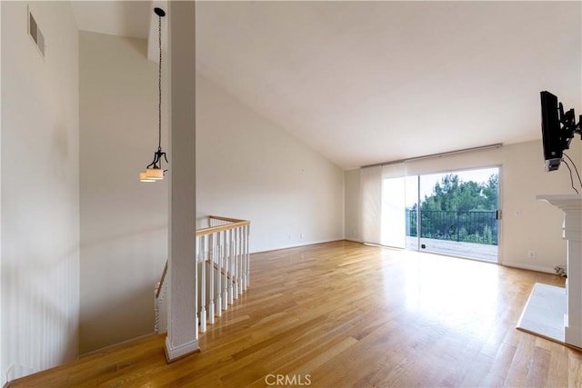 11449 Tampa Ave Unit 139, Porter Ranch, CA 91326 - unfurnished living room with visible vents, wood finished floors, and vaulted ceiling