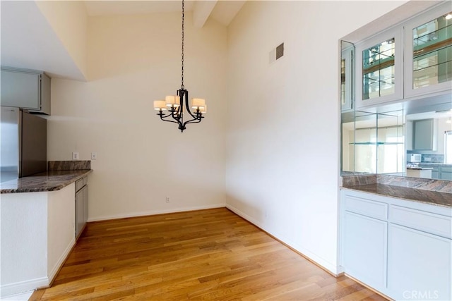 11449 Tampa Ave Unit 139, Porter Ranch, CA 91326 - unfurnished dining area featuring light wood-style floors, a wealth of natural light, a notable chandelier, and visible vents
