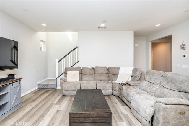 living room featuring visible vents, baseboards, stairway, recessed lighting, and light wood-style flooring
