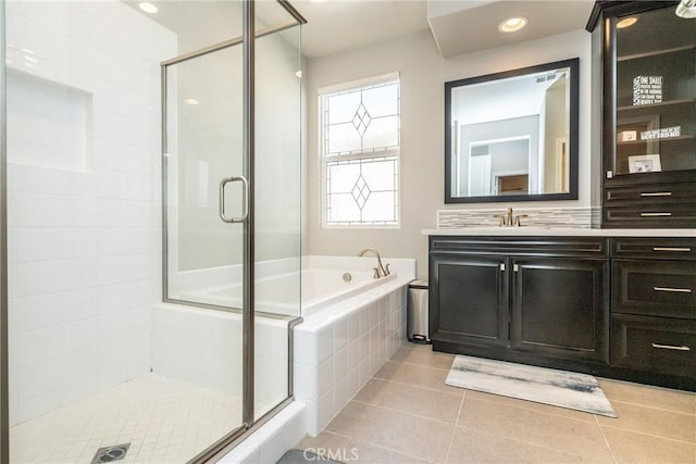bathroom featuring tile patterned flooring, a garden tub, a stall shower, and vanity
