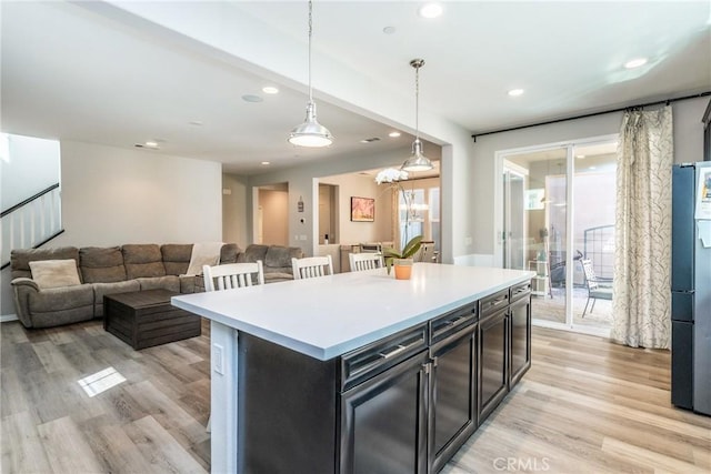 kitchen with light wood-type flooring, recessed lighting, and hanging light fixtures