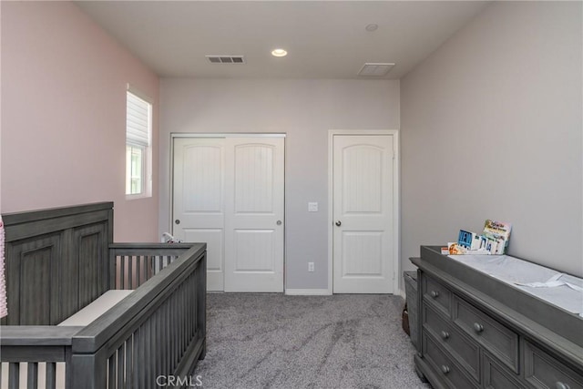 bedroom with visible vents, baseboards, carpet floors, and a closet