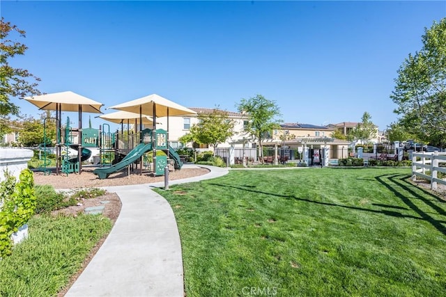 communal playground with fence and a yard