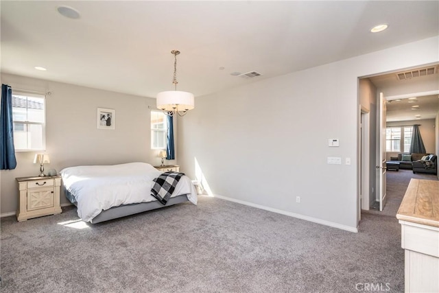 carpeted bedroom featuring an inviting chandelier, baseboards, recessed lighting, and visible vents