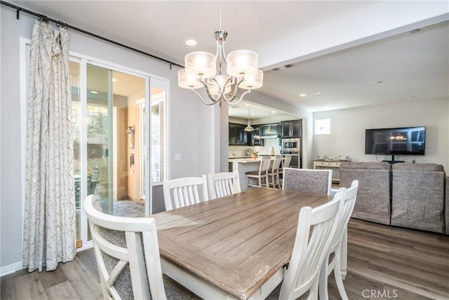 dining area with visible vents, wood finished floors, baseboards, an inviting chandelier, and recessed lighting