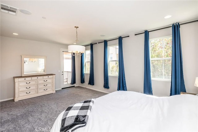 carpeted bedroom with an inviting chandelier, baseboards, multiple windows, and visible vents