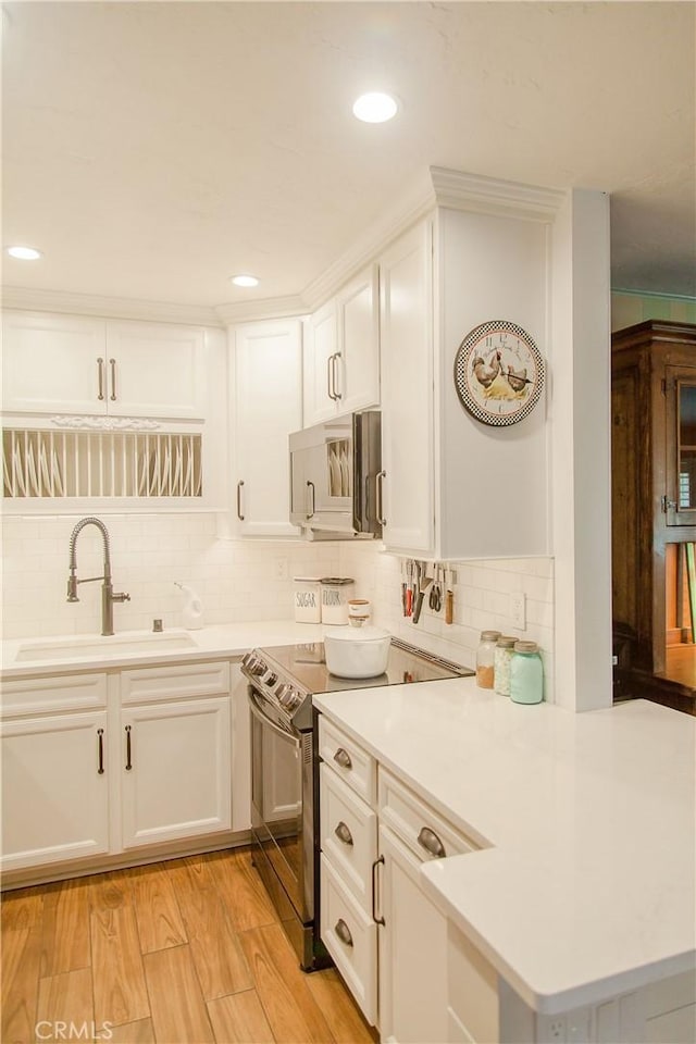 3139 E Chapman Ave Unit 14A, Orange, CA 92869 - kitchen with appliances with stainless steel finishes, a sink, decorative backsplash, light countertops, and white cabinets