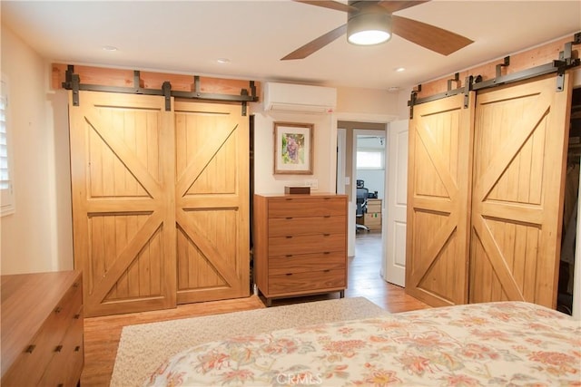 3139 E Chapman Ave Unit 14A, Orange, CA 92869 - bedroom with a barn door, a wall mounted AC, light wood-type flooring, and recessed lighting