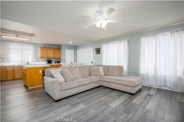 living area with a ceiling fan and light wood-style flooring
