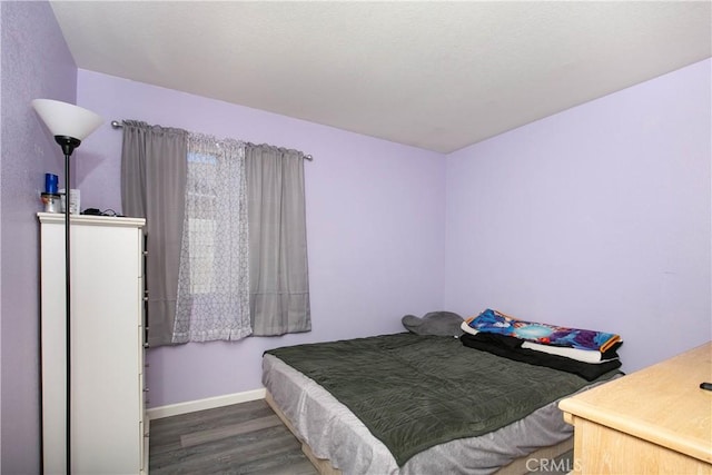 bedroom with baseboards and wood finished floors