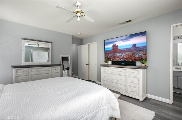 bedroom with a ceiling fan, baseboards, visible vents, connected bathroom, and dark wood-type flooring
