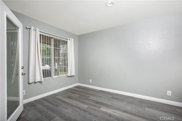spare room featuring baseboards and wood finished floors