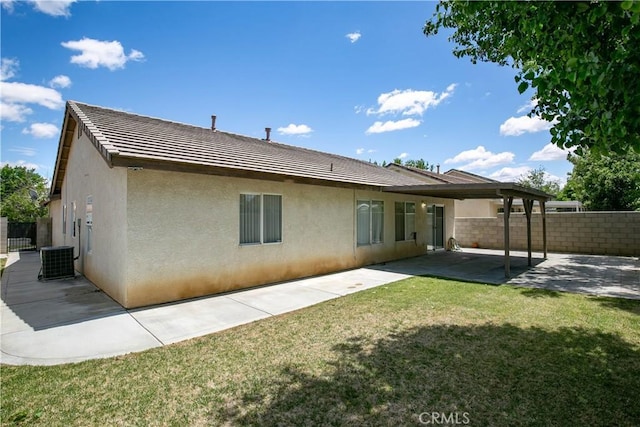 back of property featuring a yard, stucco siding, fence, and a patio