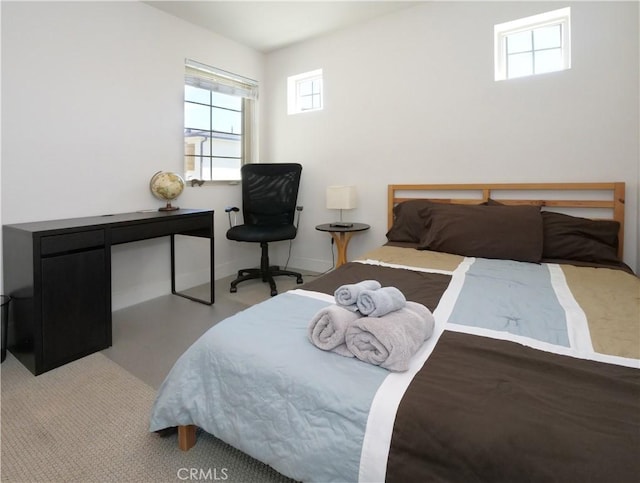 bedroom featuring baseboards and multiple windows
