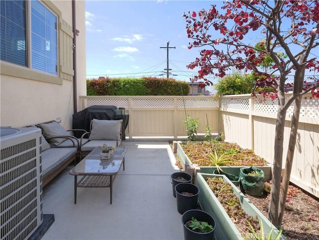 view of patio featuring fence, central AC unit, an outdoor hangout area, and a vegetable garden