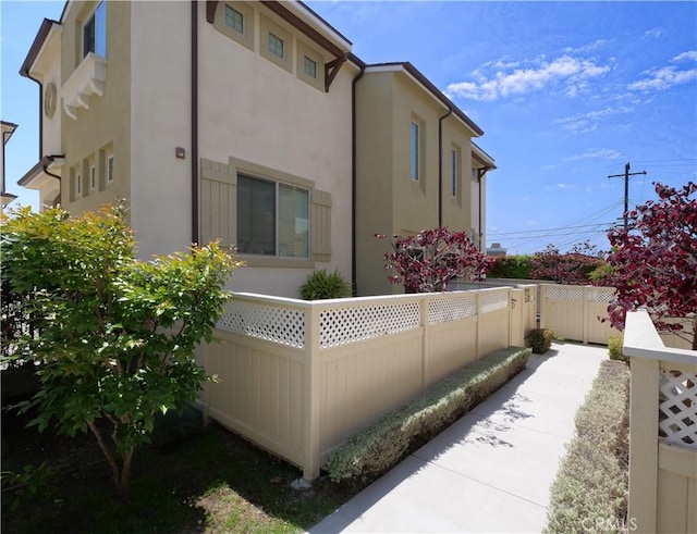 view of home's exterior featuring stucco siding and fence