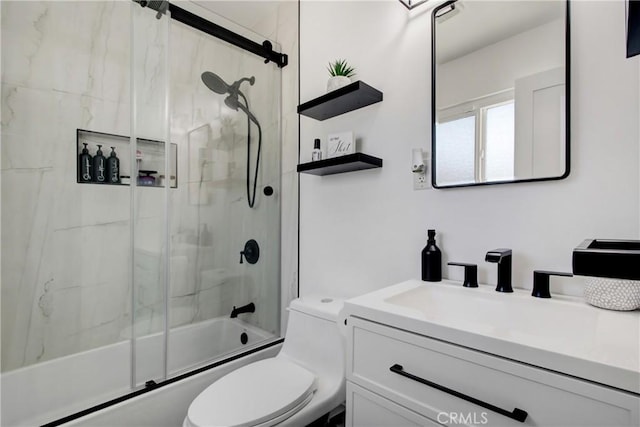 bathroom featuring vanity, toilet, and shower / bath combination with glass door