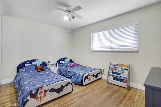 bedroom featuring baseboards, ceiling fan, and wood finished floors