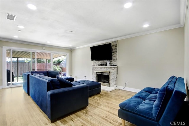 living room featuring visible vents, ornamental molding, and light wood finished floors