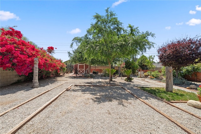 view of yard featuring a storage shed, an outbuilding, and a fenced backyard