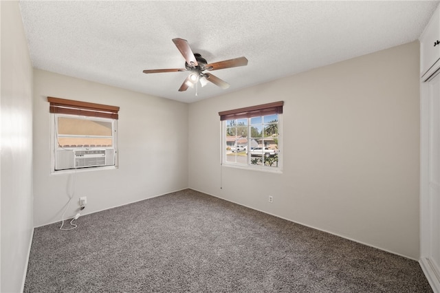 carpeted spare room featuring cooling unit, a ceiling fan, and a textured ceiling