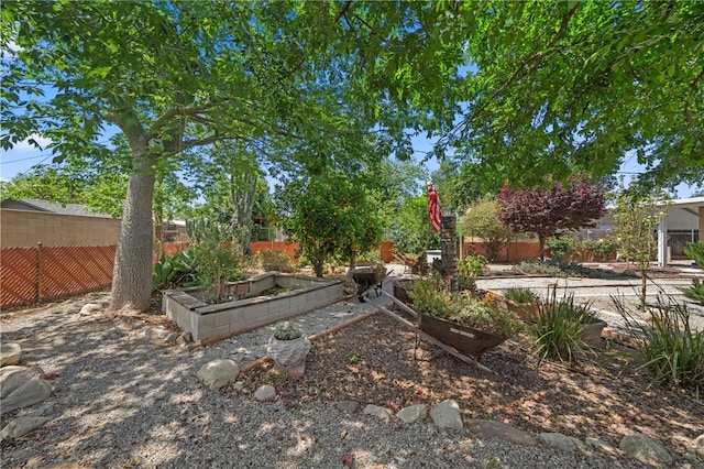 view of yard featuring a fenced backyard and a garden