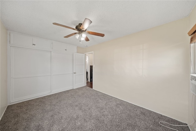 unfurnished bedroom featuring carpet flooring, a textured ceiling, and ceiling fan