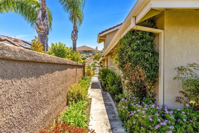 view of property exterior with fence, a gate, and stucco siding