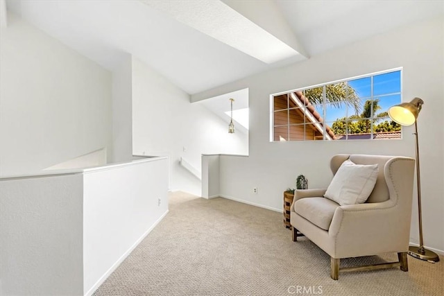 sitting room featuring baseboards, an upstairs landing, and carpet