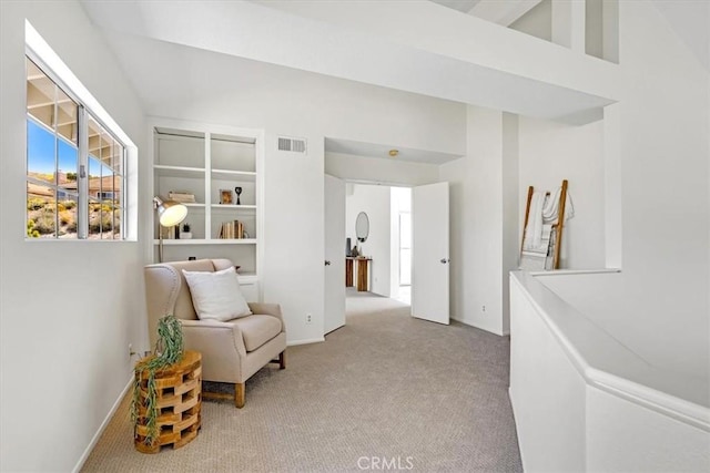 living area featuring light colored carpet, baseboards, and visible vents