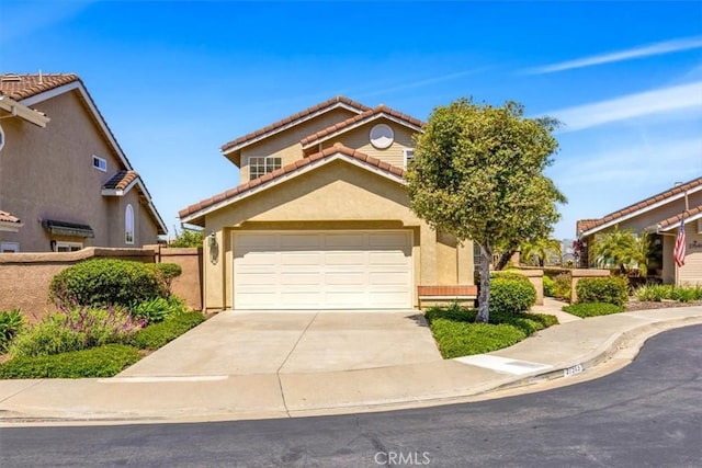 traditional-style house featuring fence, a tile roof, a garage, stucco siding, and concrete driveway